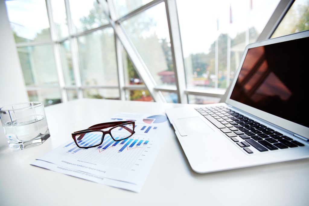 Laptop and business documents on the table at office