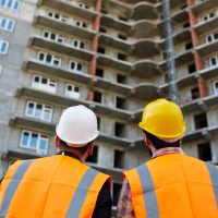 Backs of men in uniform looking at new building